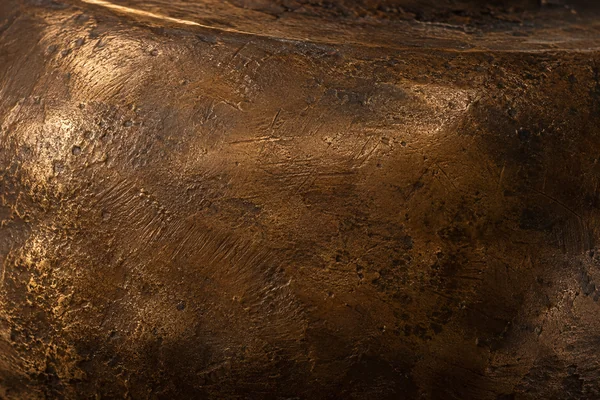Dark warm bronze has softly worn highlights, small scratches and mottled patina.