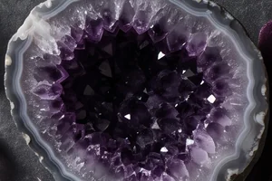 Deep violet amethyst crystals inside a grey agate rind.