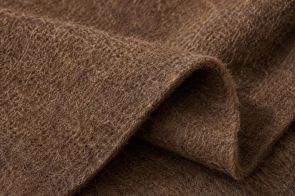 Warm brown felt shows compressed wool fibers and a soft folded edge.