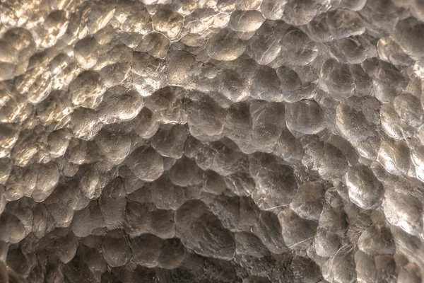 Small shallow hammer marks scatter soft highlights across silver.