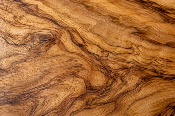 Honey-colored olive wood has dramatic dark curling grain and a smooth finish.