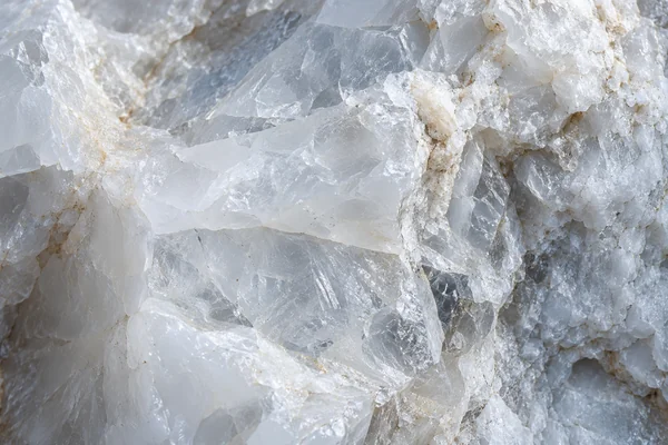Milky white quartz has translucent fractured facets and cool mineral shadows.