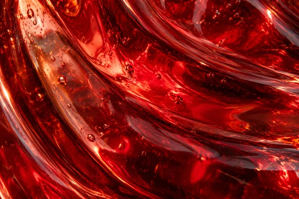 Ruby red blown glass with curved reflections, small bubbles, rippled surfaces and deep crimson shadows.