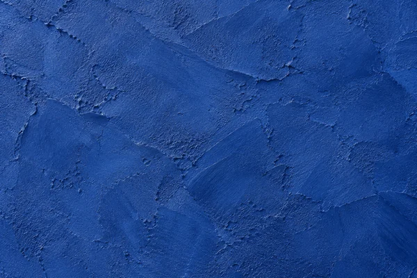 Matte ultramarine mineral plaster with layered blue pigment, fine trowel marks and chalky surface variations.
