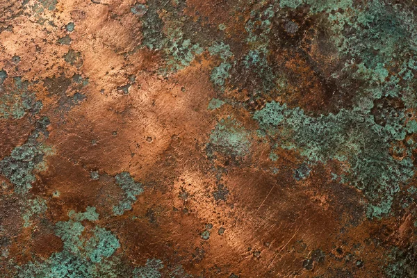 Partly weathered copper with dark oxidation and blue-green islands.